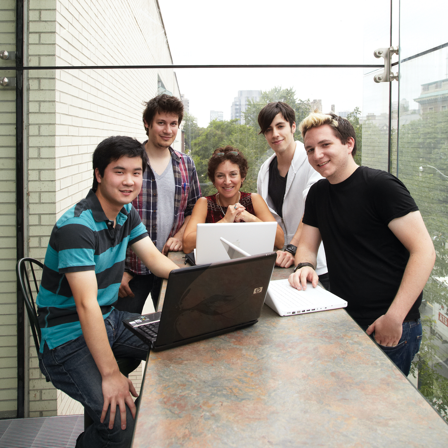 Professor with students smiling into camera