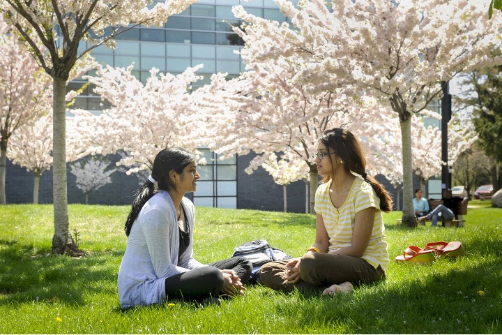 Two students sitting outside in a conversation