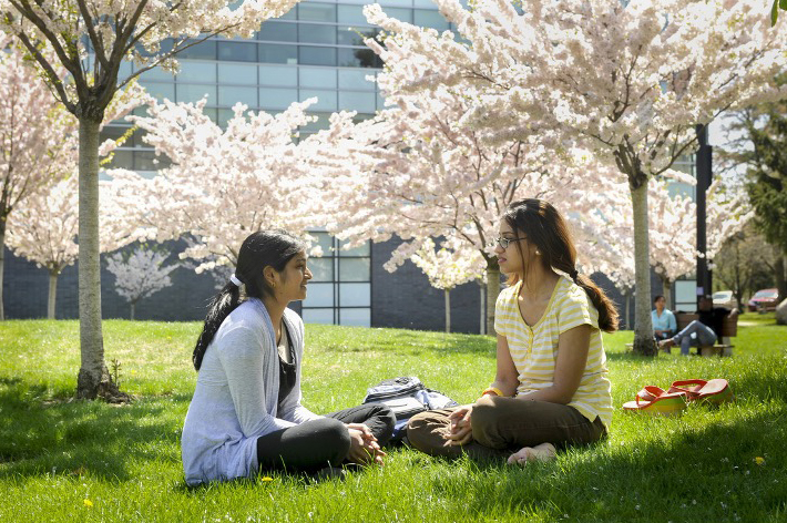 Two students sitting outside in a conversation