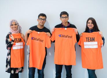 Team of undergrad students holding up DatFest shirts