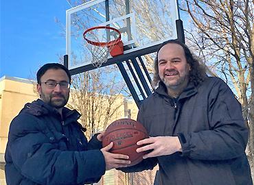Professor Jeffrey Rosenthal and his brother holding a basketball standing on the court